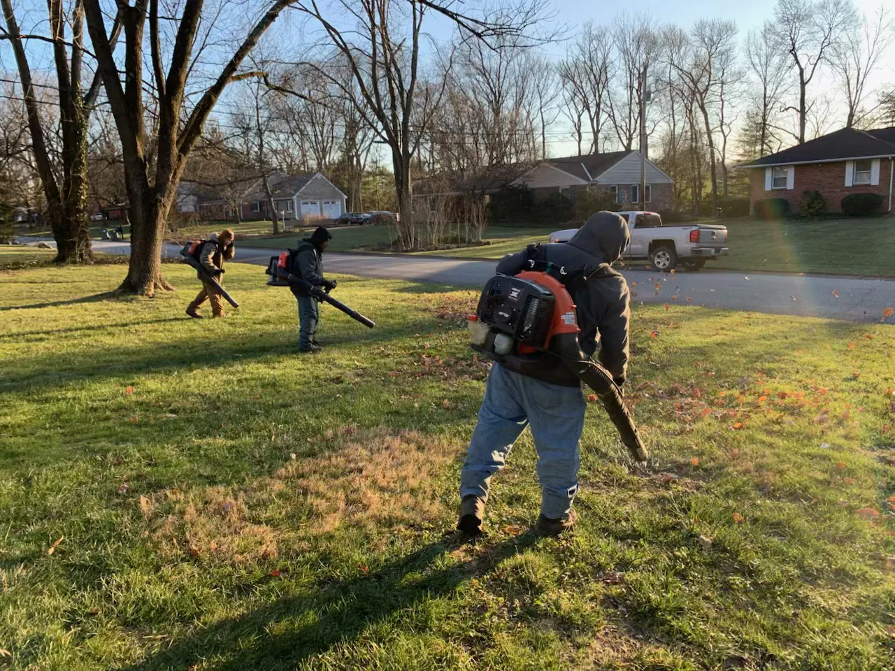 The Delaware Lawn Crew clearing fall leaves across a property.