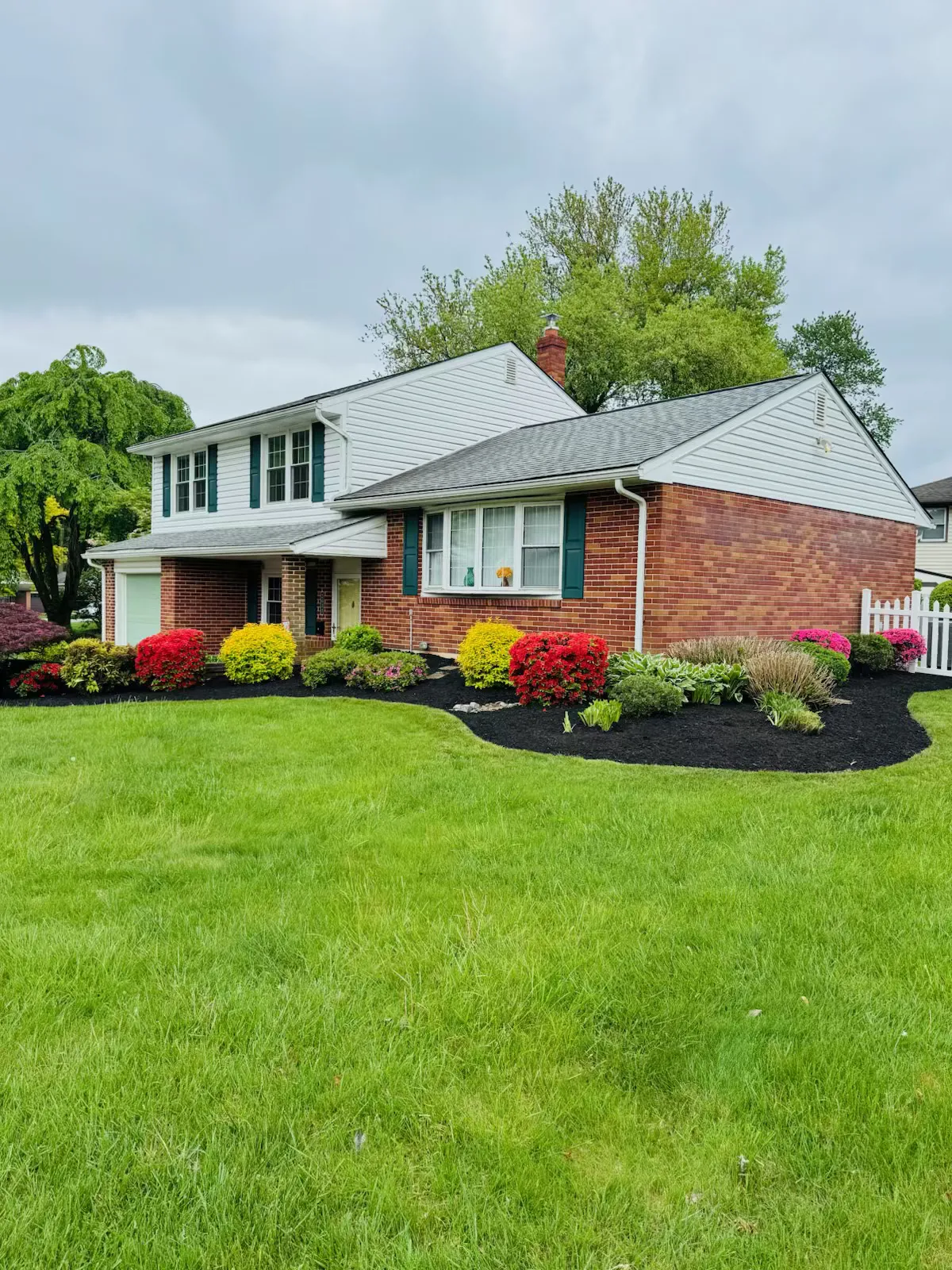 A Delaware home with colorful, freshly mulched flower beds.
