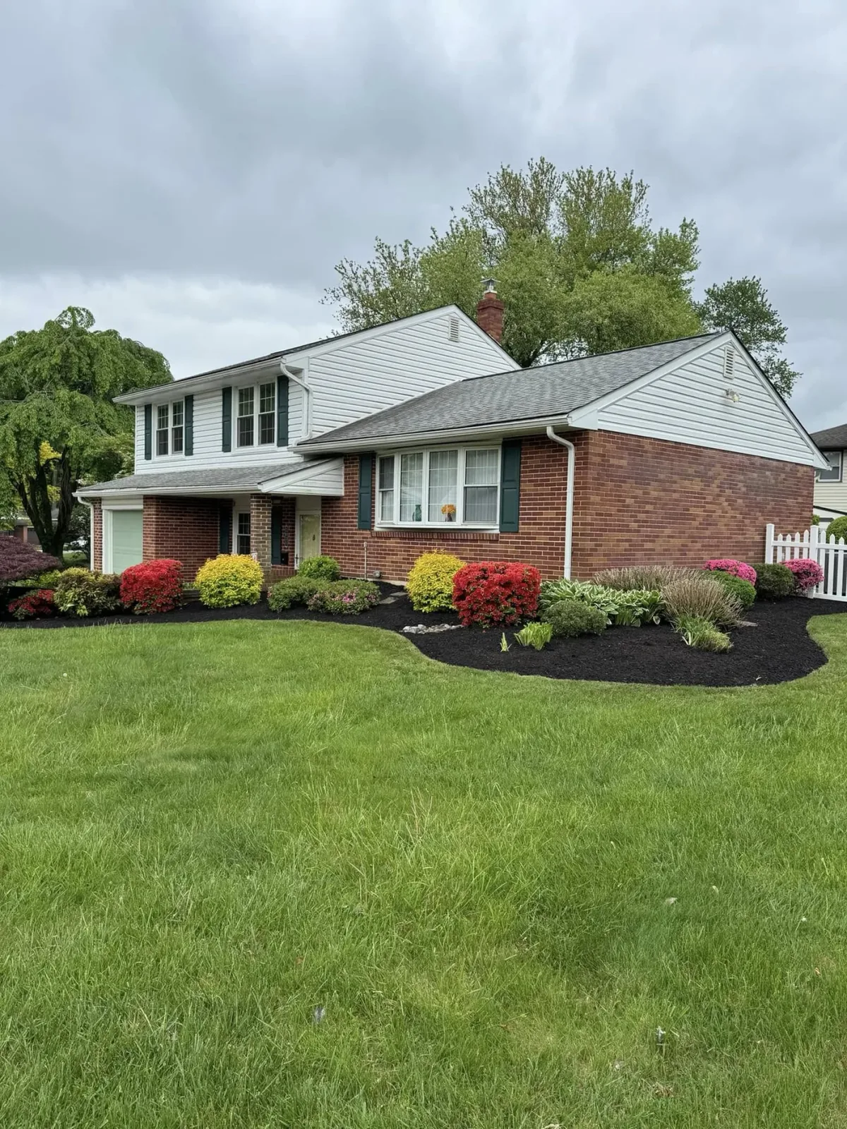 A New Castle County home with a full front-bed makeover, fresh mulch and shrubs.