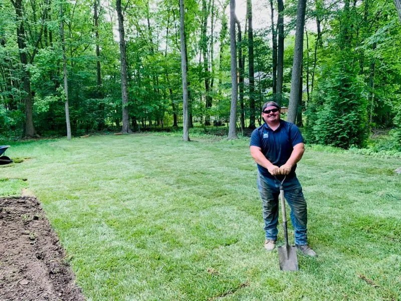 A Delaware Lawn Crew member on a renewed, deep-green lawn