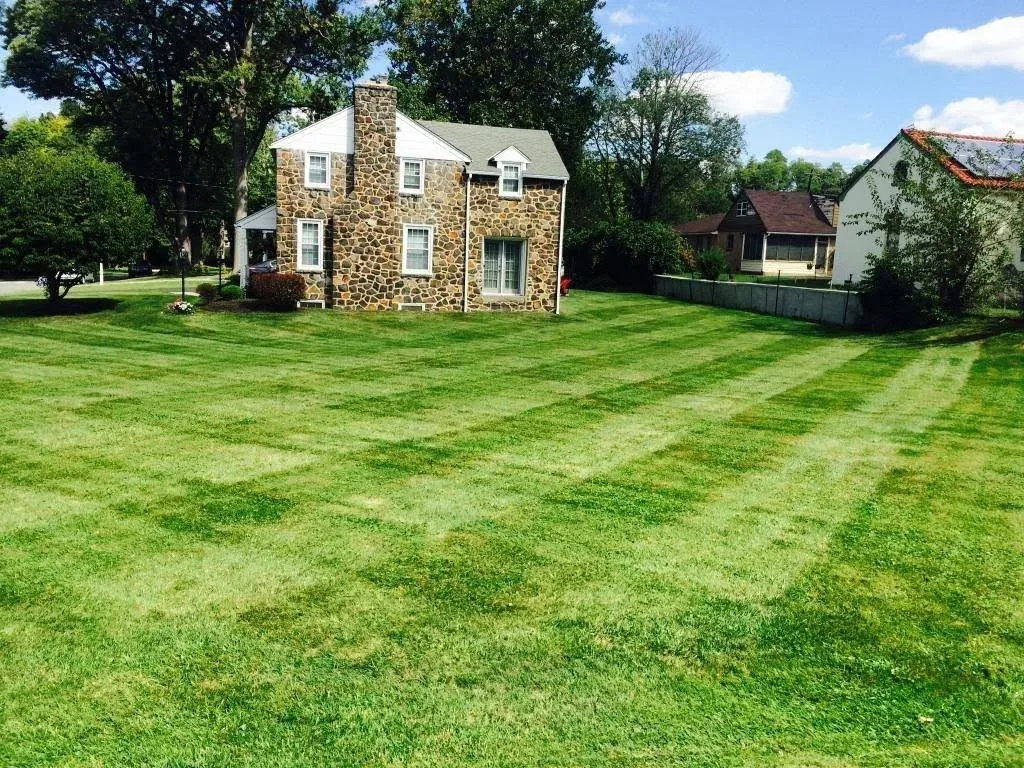 A big striped lawn in front of a Delaware stone house