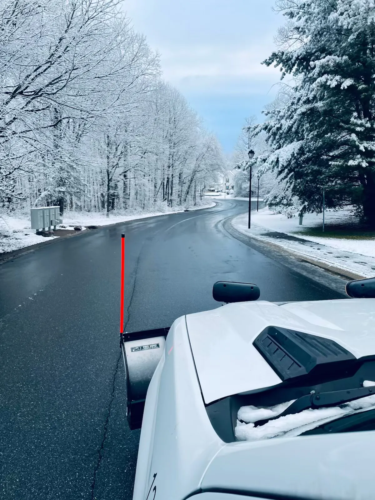 A Delaware Lawn Crew plow truck clearing a snow-covered New Castle County road.